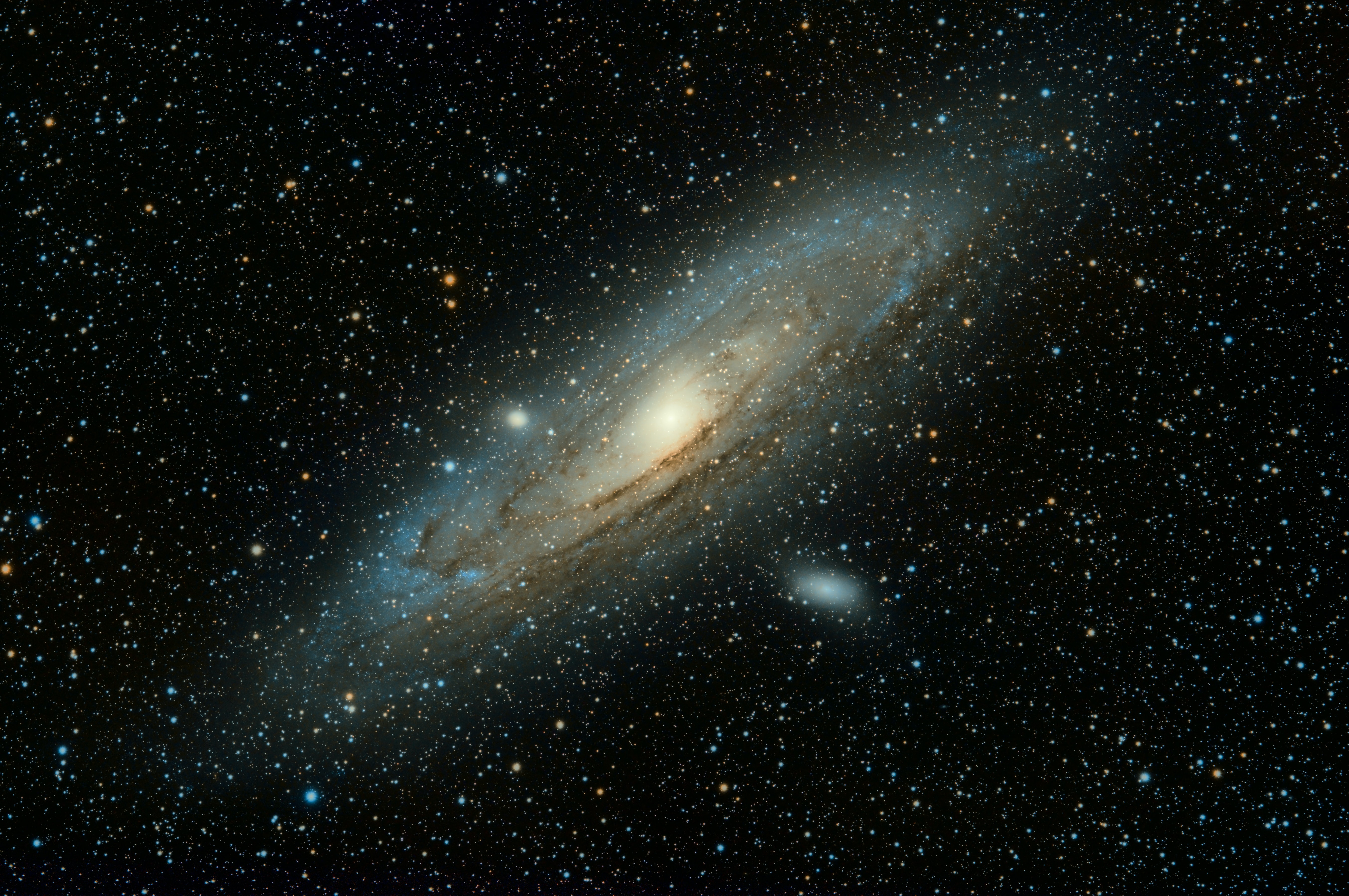 The rust orange and blue swirls of Andromeda Galaxy set against countless stars in the night sky.